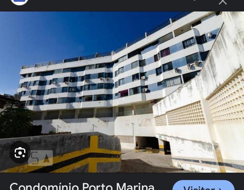 a large apartment building in front of a building at Porto Marina in Salvador
