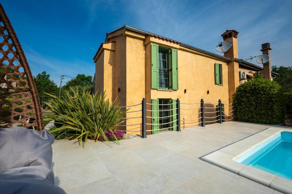 a house with a swimming pool in front of it at Villa Nika - Rustic Stone House with Heated Pool in Rasopasno