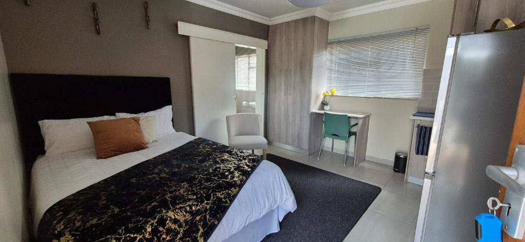 a bedroom with a bed and a desk in it at Ekuhlaleni Room 6 in Pretoria