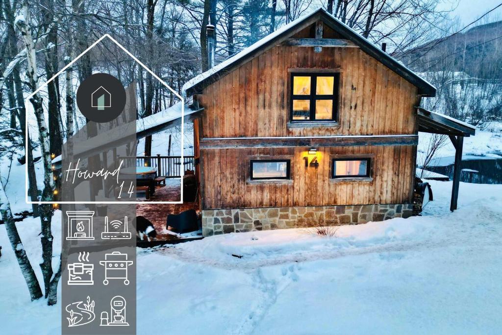 ein Blockhaus im Schnee mit einem Schild davor in der Unterkunft Le 14 Chalets Howard - Spa-Shower-Hammock-Bromont in Bromont