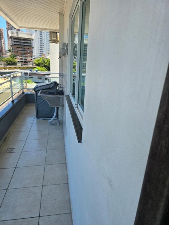 een balkon met een wastafel aan de zijkant van een gebouw bij Férias em Itapema 04 in Itapema