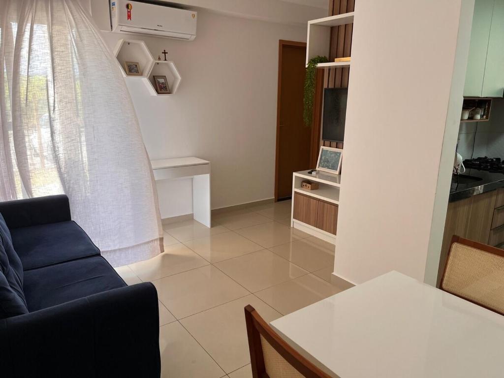 un soggiorno con un divano blu e una cucina di Sossego Potiguar a Parnamirim