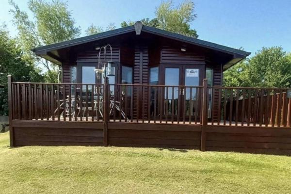 una grande cabina in legno con un ampio ponte di Lodge Retreat 8 - Haggerston Castle a Berwick-Upon-Tweed