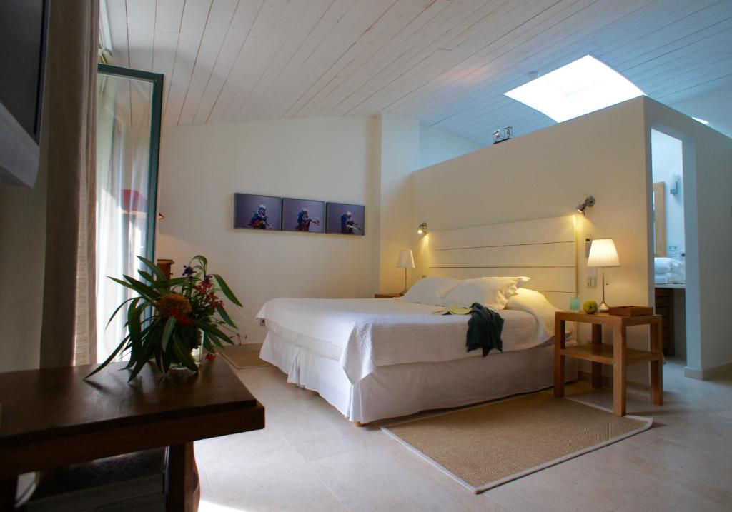 a bedroom with a large white bed and a skylight at Campagne les Jumeaux in Saint-Tropez