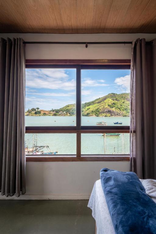 维多利亚Hostel Chico Lessa的卧室窗户享有水体美景