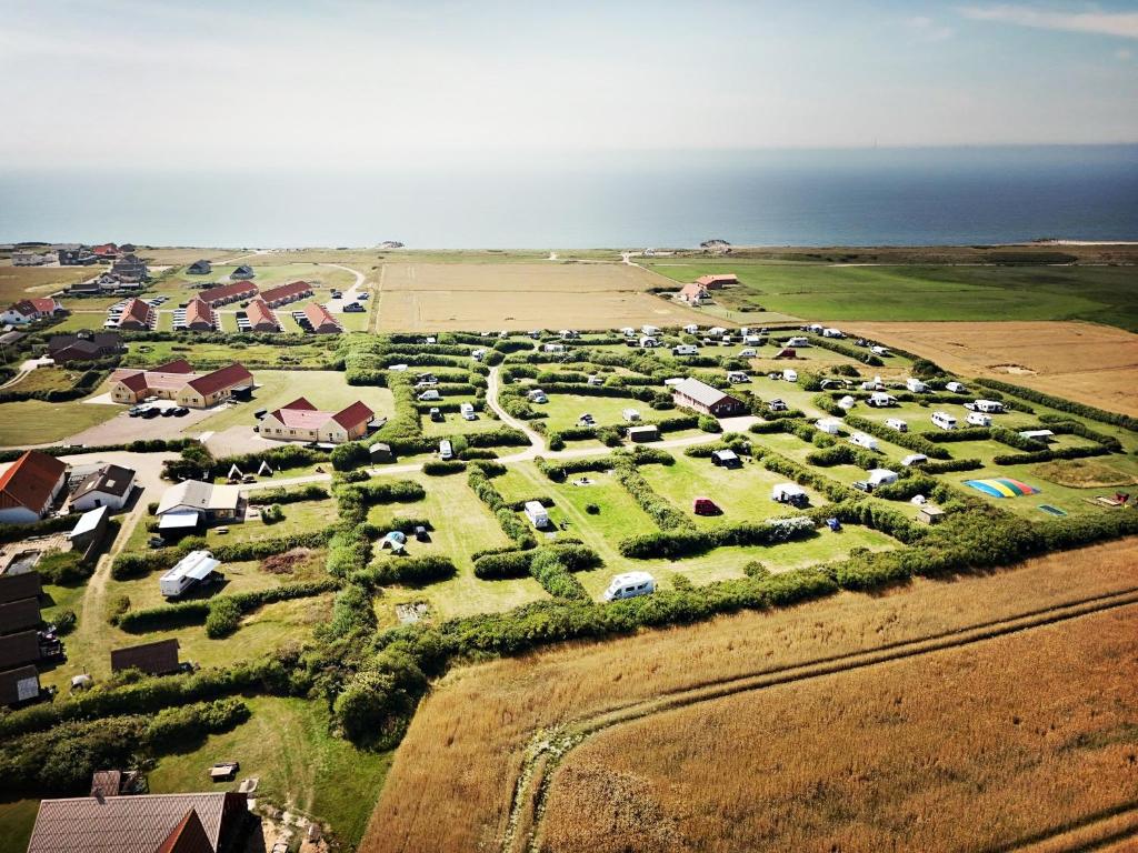 Una vista aérea de una granja con coches estacionados. en Bovbjerg Camping, en Lemvig