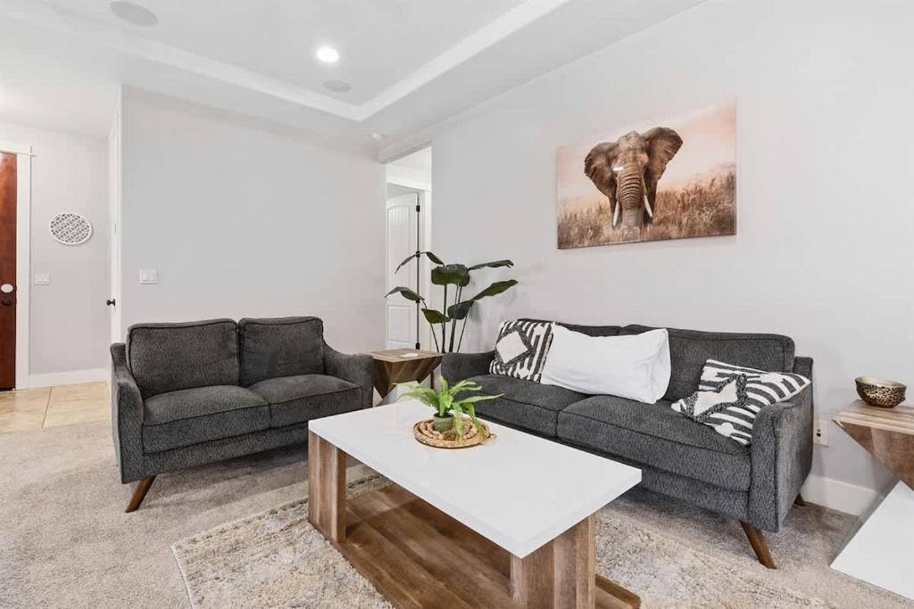 ein Wohnzimmer mit einem Sofa und einem Elefantenmalerei an der Wand in der Unterkunft Sensible Safari Sleeps 10 in Meridian