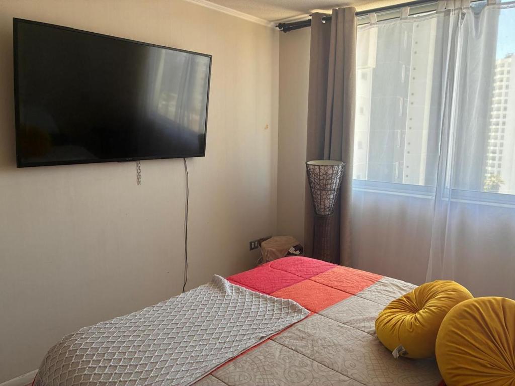 a bedroom with a flat screen tv on the wall at Depto playa herradura in Coquimbo