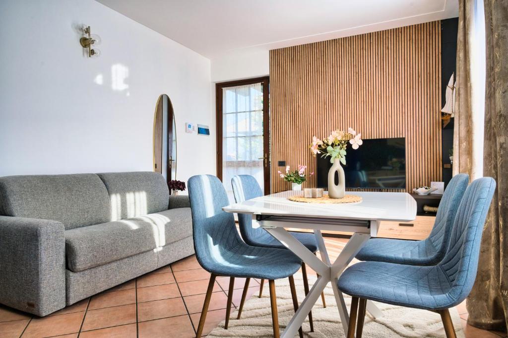 ein Wohnzimmer mit einem Tisch und blauen Stühlen in der Unterkunft Belloro in Zanica