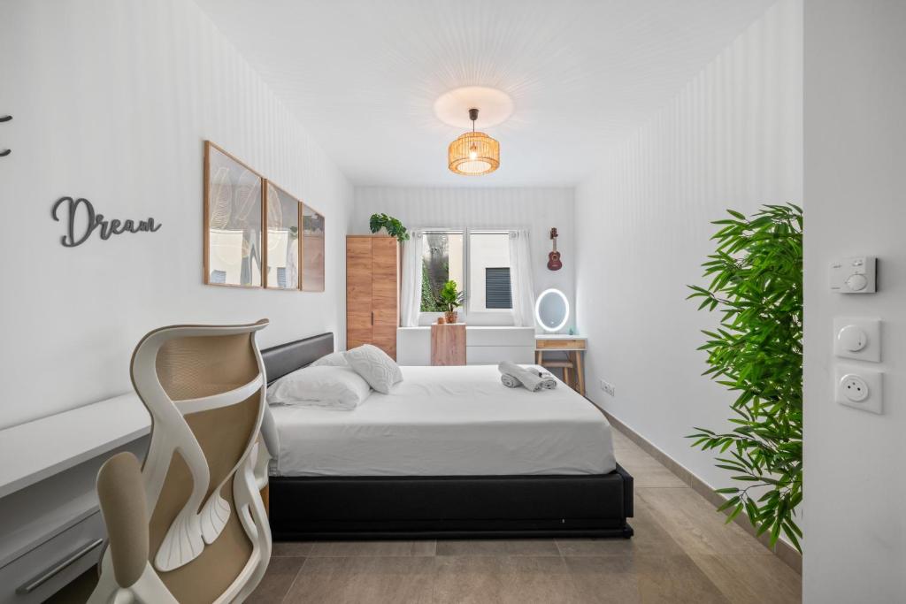 ein weißes Schlafzimmer mit einem Bett und einer Pflanze in der Unterkunft Modern Luxury - Sea View over Èze Village in Èze
