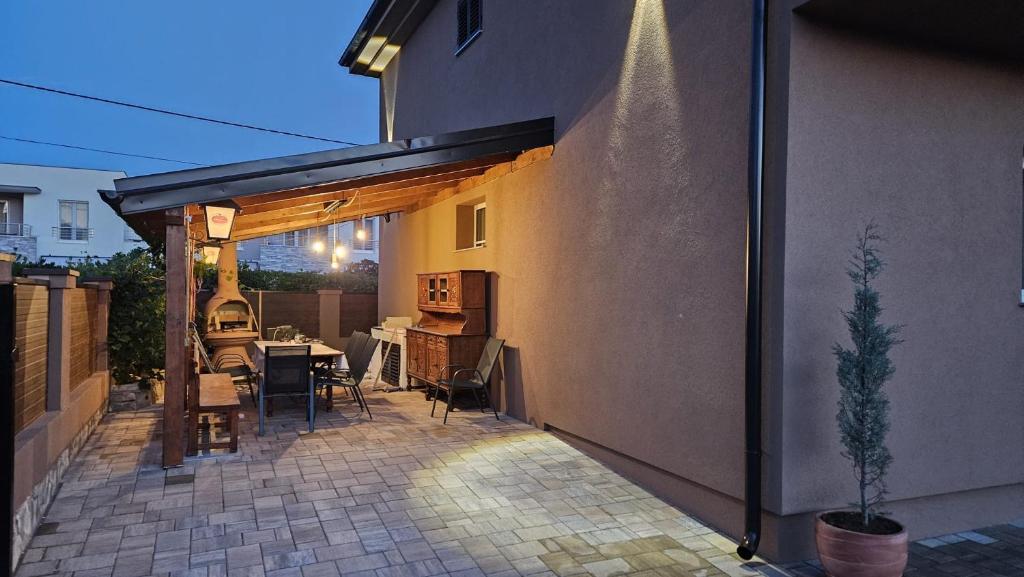 een terras met een tafel en stoelen en een gebouw bij Villa Punta in Privlaka