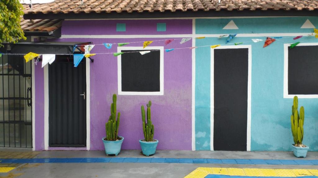 una casa colorata con dei cactus di fronte di Kitnet 1 ambiente a Campina Grande