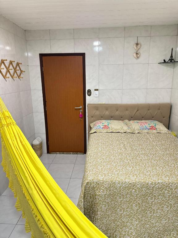 a bedroom with a bed with a yellow net at Kitnet 1 ambiente in Campina Grande