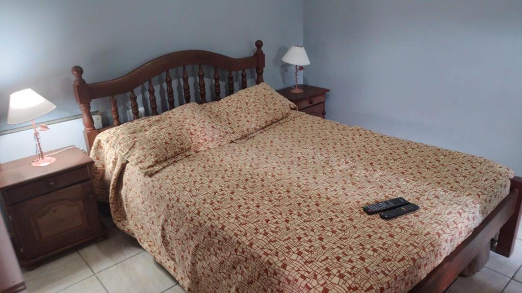 un lit avec un couvre-lit marron et une télécommande dessus dans l'établissement Departamento en Sinsacate, à Sinsacate