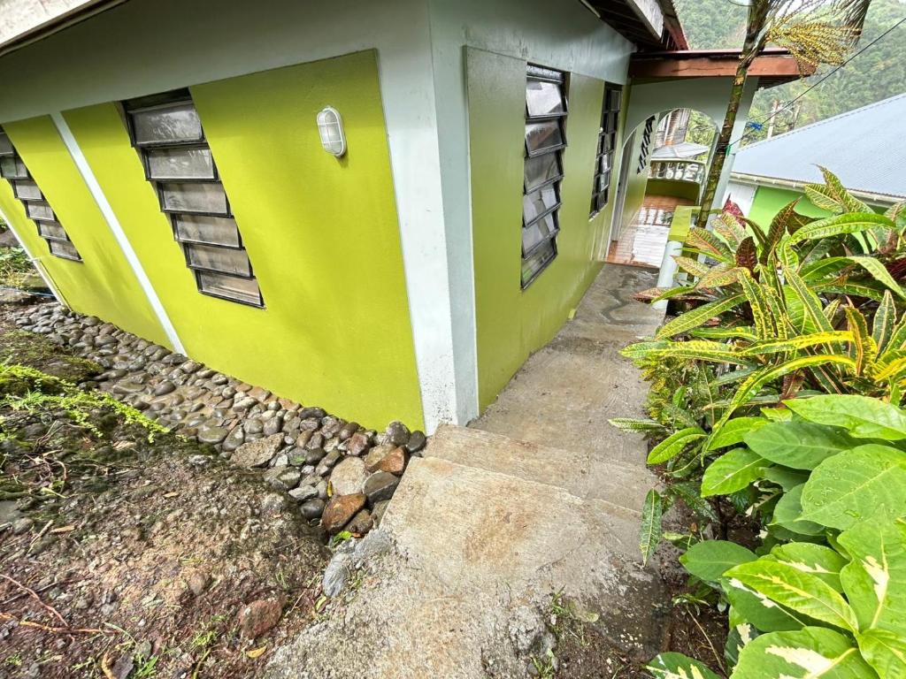 a green and white house with a pathway leading to it at C's Sunrise Escape in Roseau