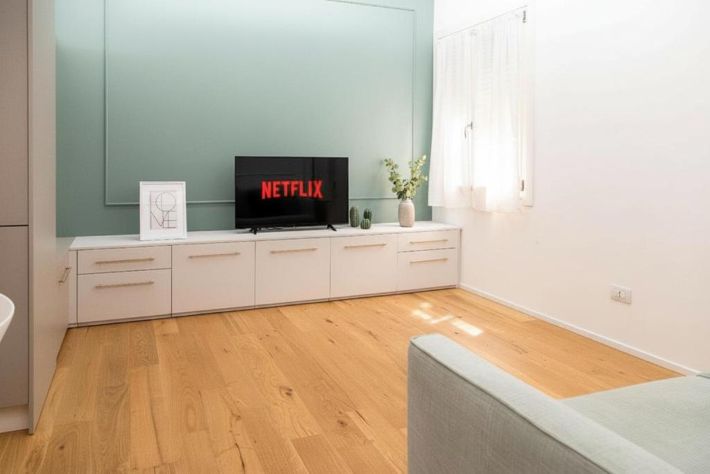 een woonkamer met een flatscreen-tv bovenop keukenkastjes bij Ca' Borsa IV - Suite con balcone in pieno centro in Treviso