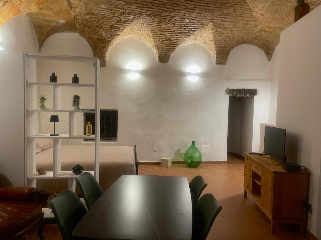 a living room with a table and chairs and a television at Casa "La Fonte" in Spoleto