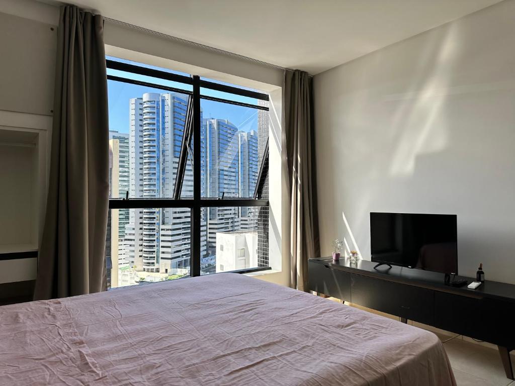 En eller flere senge i et værelse på Flat Moderno a 150m do Salvador Shopping