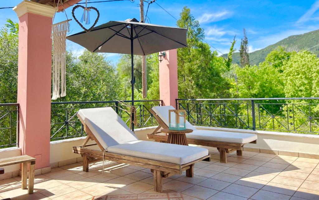 un balcone con 2 sedie e un ombrellone di Villa Valia Seaside a Ipsos