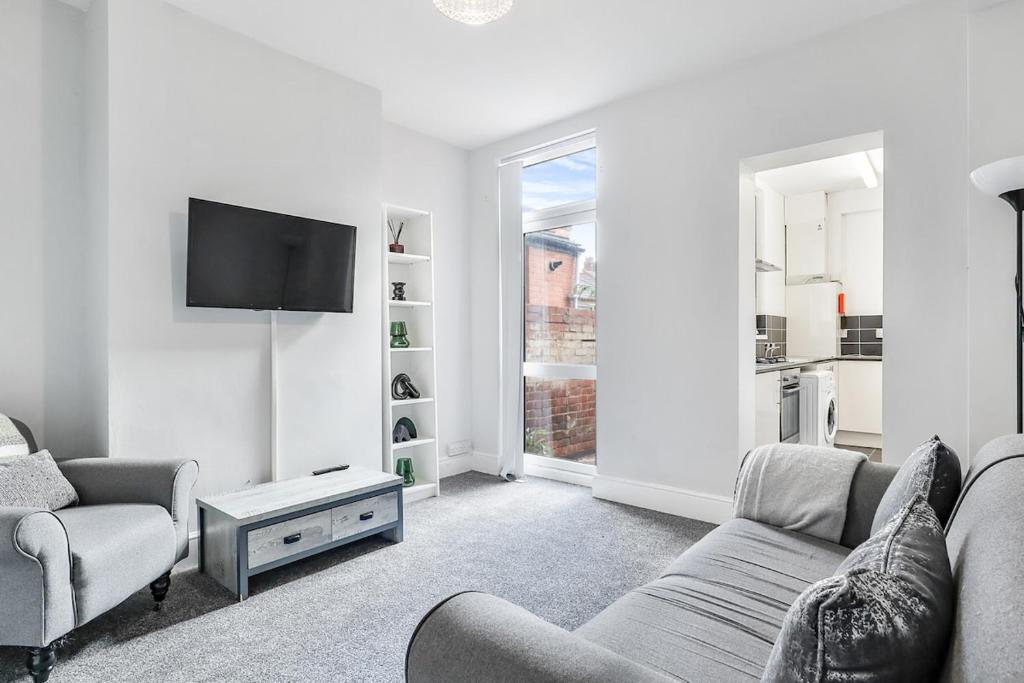 een woonkamer met een bank en een tv bij OA Housing - Spacious 2 Bedrooms in Spon End