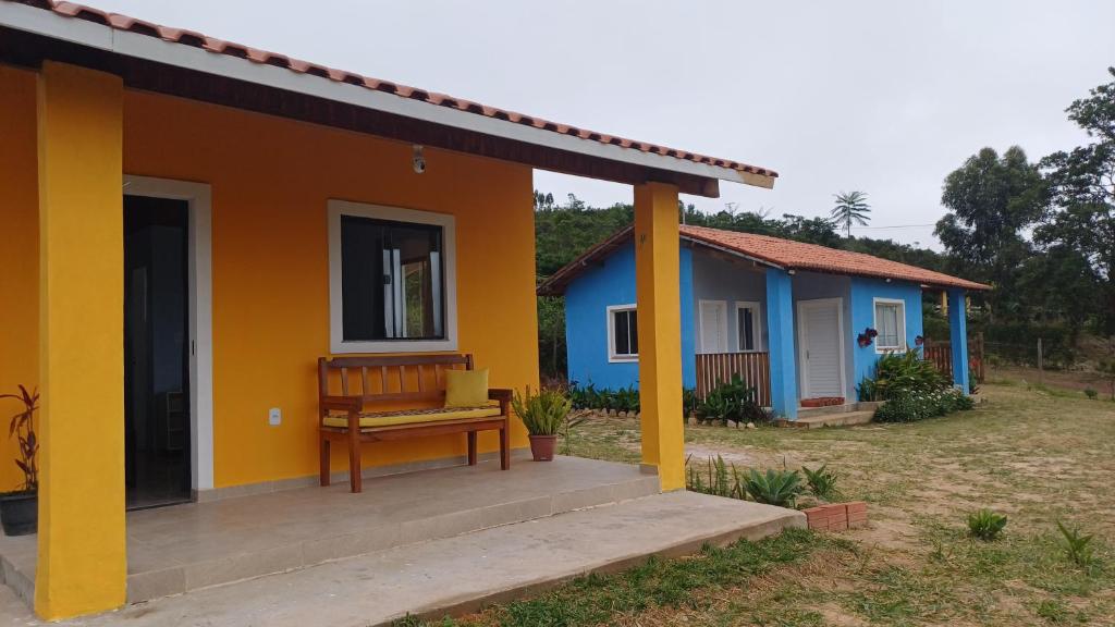 una casa con una panchina davanti di Chalé Família Canto da Graúna a Ibicoara