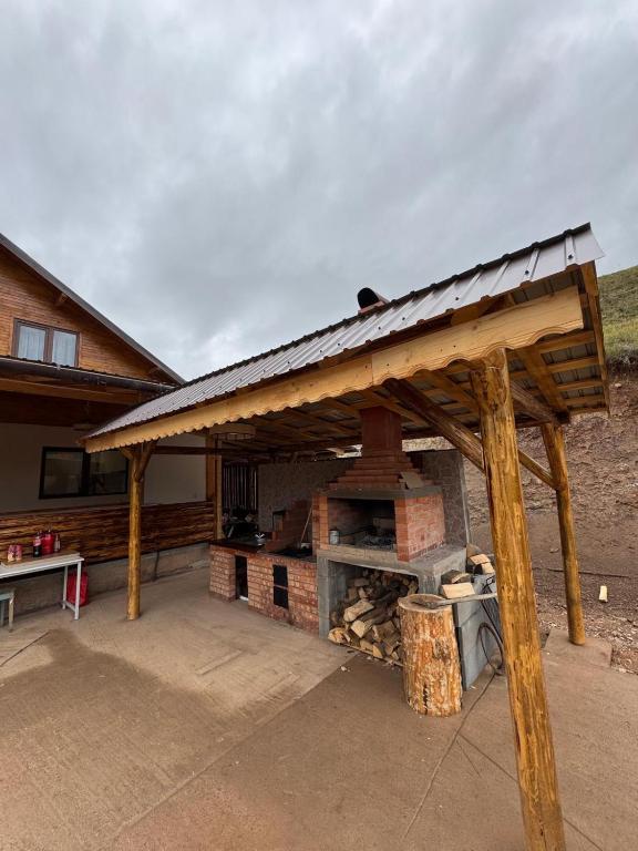 un padiglione di legno con un camino davanti a una casa di Casa Diana a Huedin