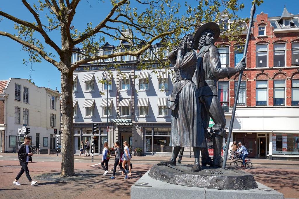 Eine Statue eines Mannes, der auf einer Straße steht. in der Unterkunft Hotel Lion D'Or in Haarlem