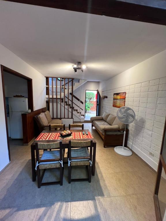 een woonkamer met een tafel en een bank bij Duplex 5 personas pinamar centro in Pinamar