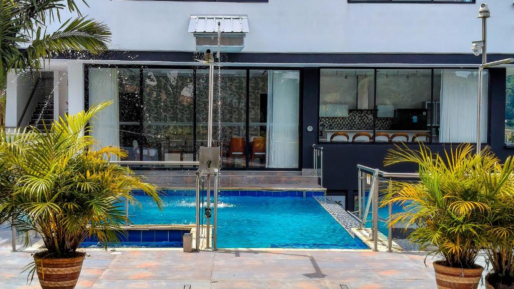 a swimming pool in front of a house at The Palms Hotel in Estación El Salto