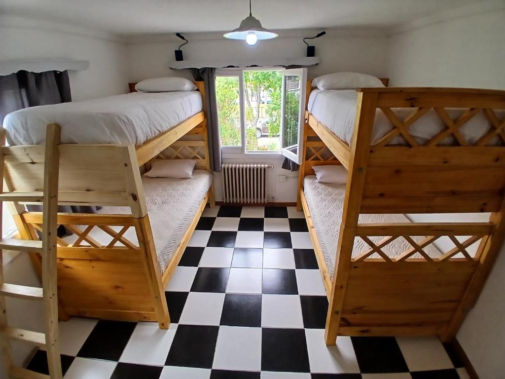 two bunk beds in a room with a checkered floor at Casa central hostel in San Carlos de Bariloche