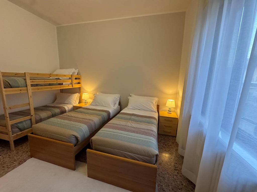 ein Zimmer mit zwei Betten und einem Etagenbett in der Unterkunft La Grande Casa di Malpensa - casa vacanze in Gallarate