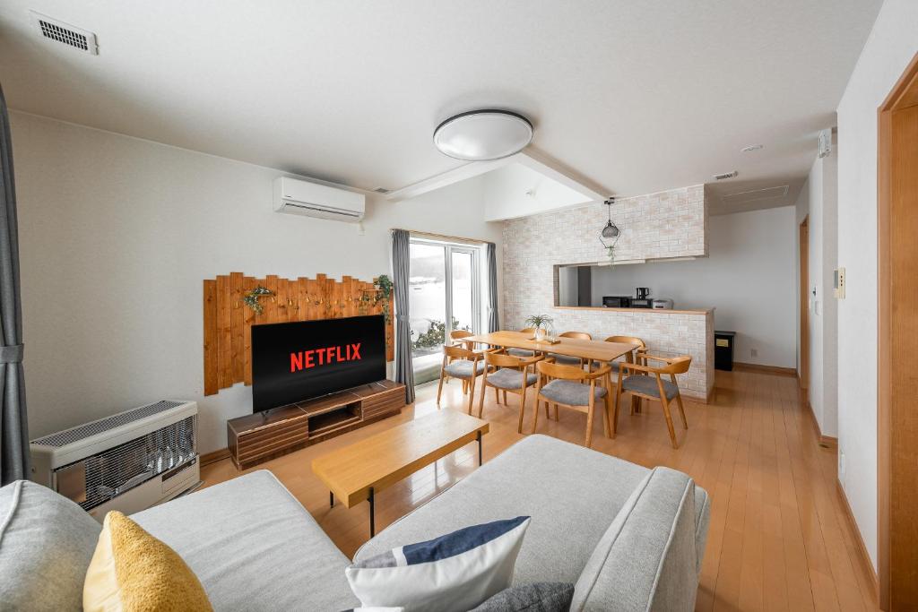 a living room with a kitchen and a dining room at Clematis in Nakafurano