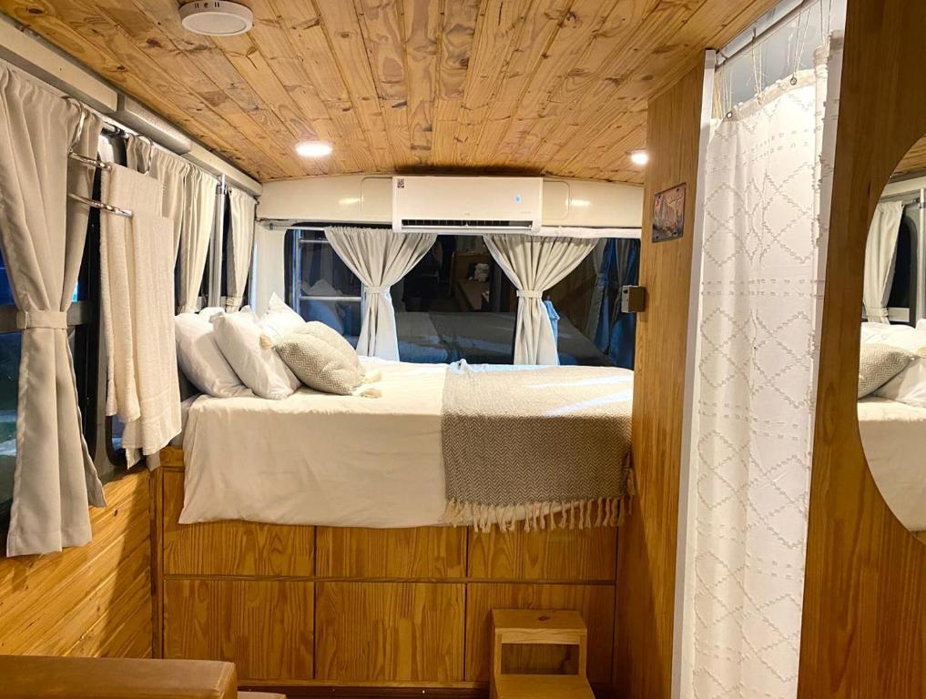 a bedroom with a bed in the back of a van at Sal da Terra Bus in Pirenópolis
