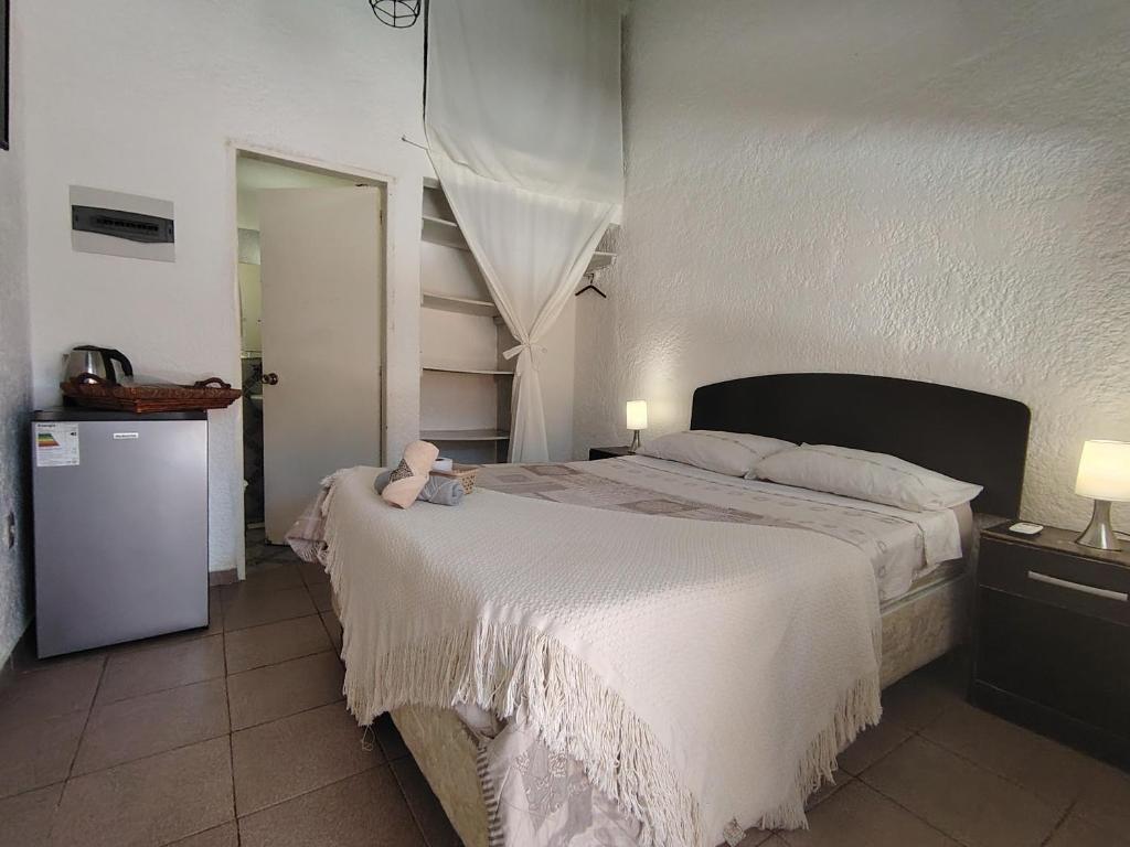 una camera da letto con un letto grande con un orsacchiotto sopra di Chula - Posada a Punta del Este