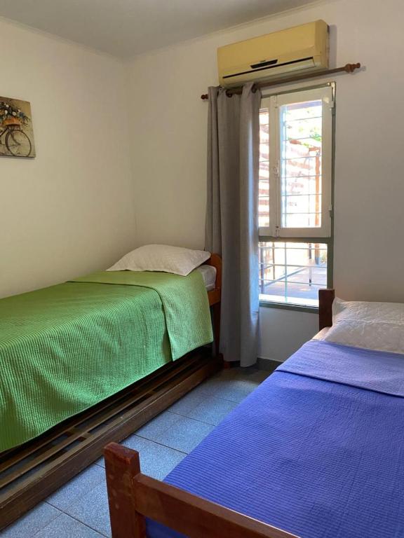 una camera da letto con due letti e una finestra di Alma del Pinal a Garupá