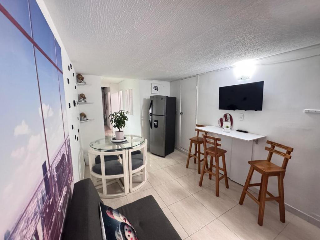 Una pequeña cocina con una mesa y un refrigerador. en Modern apartment/Studio, en Pereira