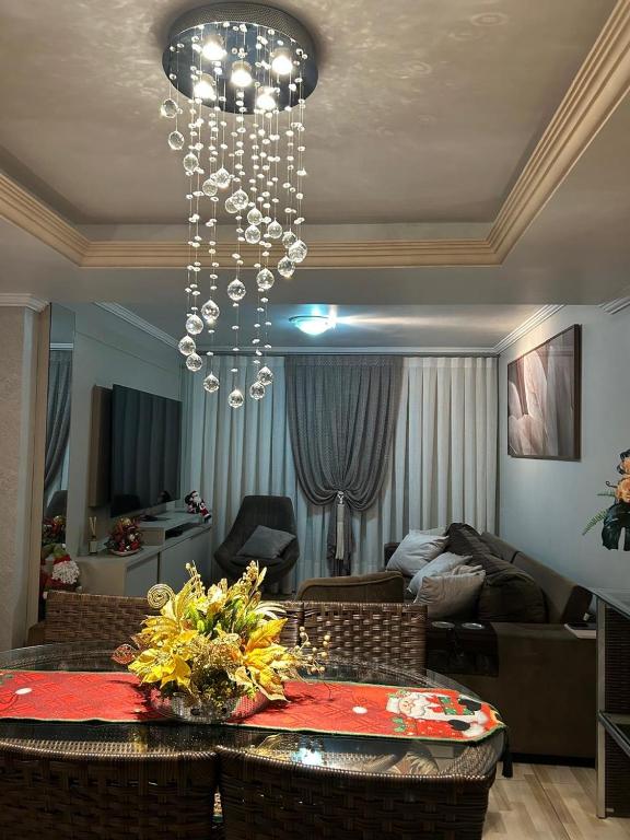 a living room with a chandelier hanging from the ceiling at Recanto familiar in Florianópolis