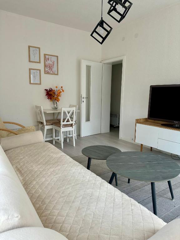 a living room with a bed and a tv and a table at Apartment DUNJA 2 Laktasi in Laktaši