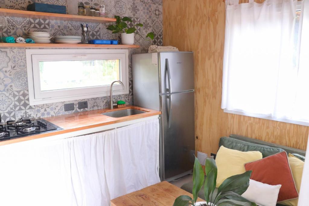 eine Küche mit einem Kühlschrank aus Edelstahl und einer Spüle in der Unterkunft La bella tiny in Epuyén