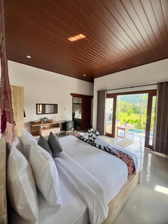 a large bedroom with a large bed and a large window at Dewi Teduh Villa in Sidemen