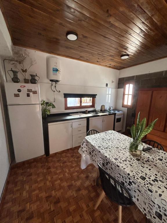 a kitchen with a table and a white refrigerator at Departamento cómodo in Concepción del Uruguay