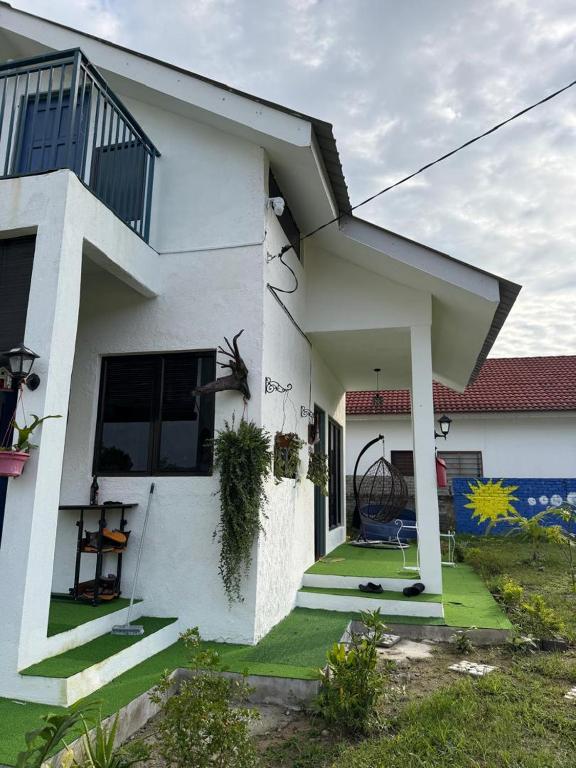 a white house with a porch and a yard at Science and Astronomy Garden in Kampung Dengkil