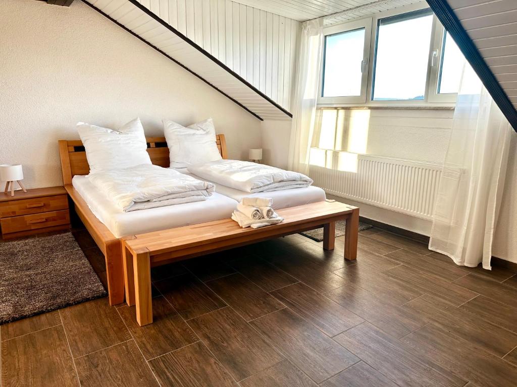 a bedroom with two beds and a table with a window at LUMI Living in Schlüsselfeld