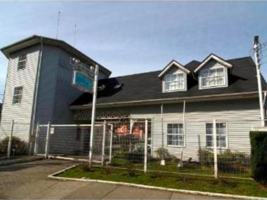 a white house with a fence in front of it at Apart Hotel Casablanca in Valdivia