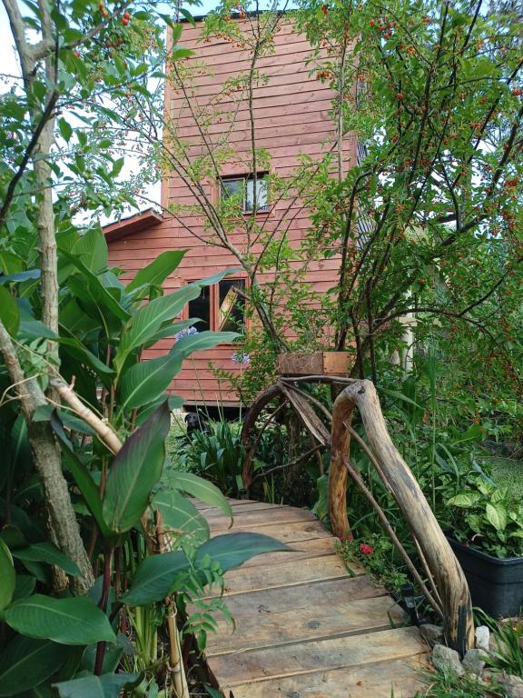 a wooden walkway in front of a pink house at Casa Iris del monte in La Pedrera