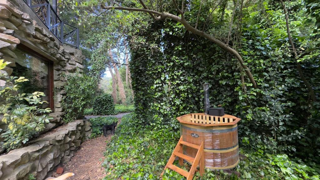 ein Holzfass neben einer Steinmauer in der Unterkunft Cabañas Arehue in Mar del Plata