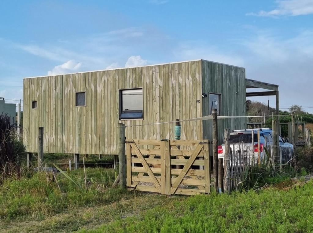 een houten huis met een hek en een hek bij Macchiato in La Pedrera