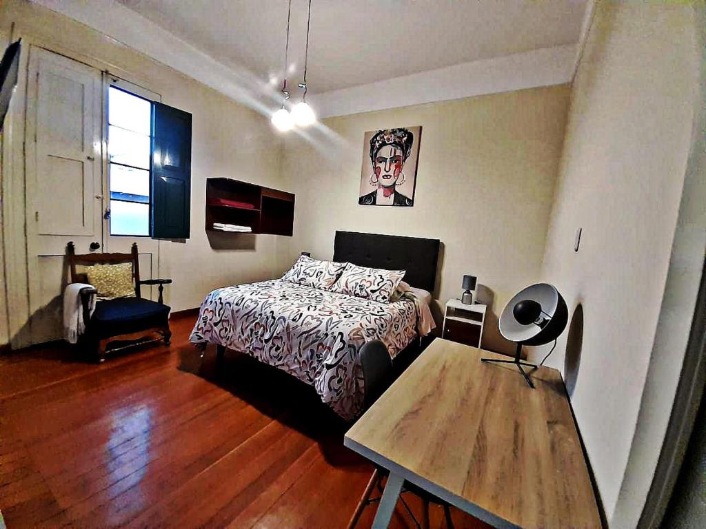 een slaapkamer met een bed en een tafel bij Santa Marta Casona in Arequipa