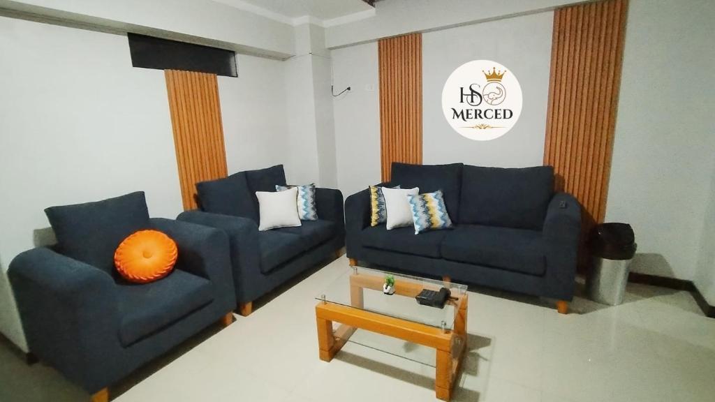 a living room with two blue couches and an orange pillow at La Merced in Juliaca