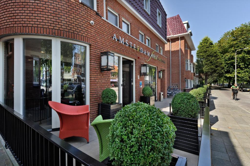 une chaise rouge assise à l'extérieur d'un bâtiment dans l'établissement Amsterdam Forest Hotel, à Amstelveen